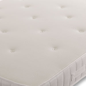 Aleena Sprung Memory Mattress by Mattress Supermarket showing a neatly made bed with white bedding and a plush headboard.