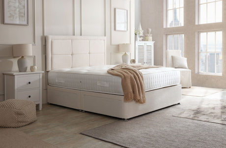 Riga divan bed set with button-bordered headboard, featuring a modern upholstered frame and plush bedding for a stylish bedroom look